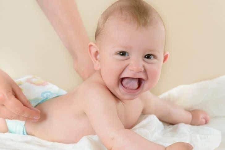 Niño sonriendo con masaje de aceites esenciales para bebés