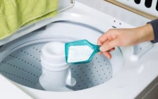 Mujer echando jabón casero para lavadora.