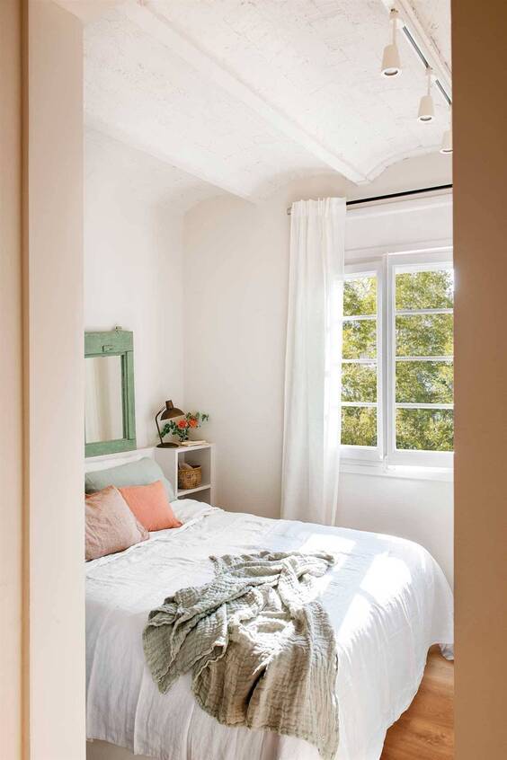 Decoracion de habitación pequeña de color blanco, con iluminación natural y focos en el techo