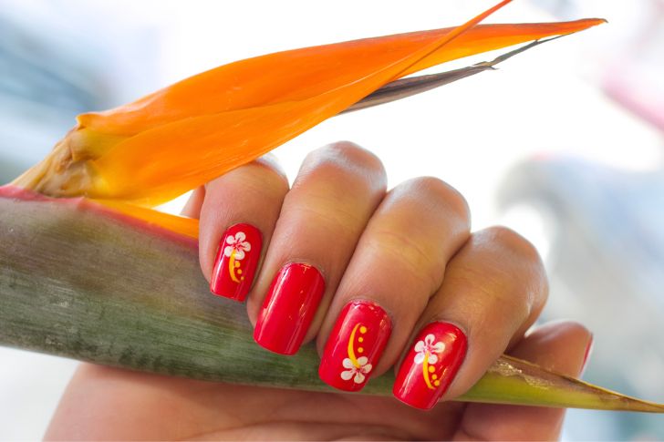 Uñas de verano: manicura floral con uñas rojas con flores blancas