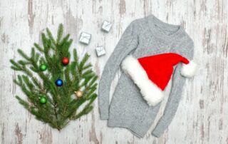 Grueso suéter gris y el sombrero de santa con la rama de abeto decorado para un outtit temático de navidad .
