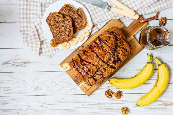 Slice of chocolate banana bread on a wooden surface.